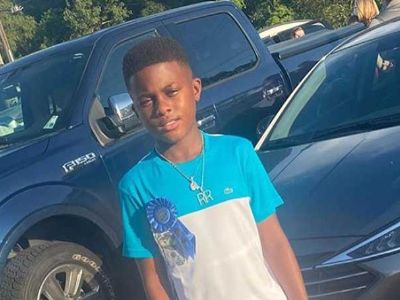 Ivy Ray Hatch is wearing a badge on his tee and a chain.